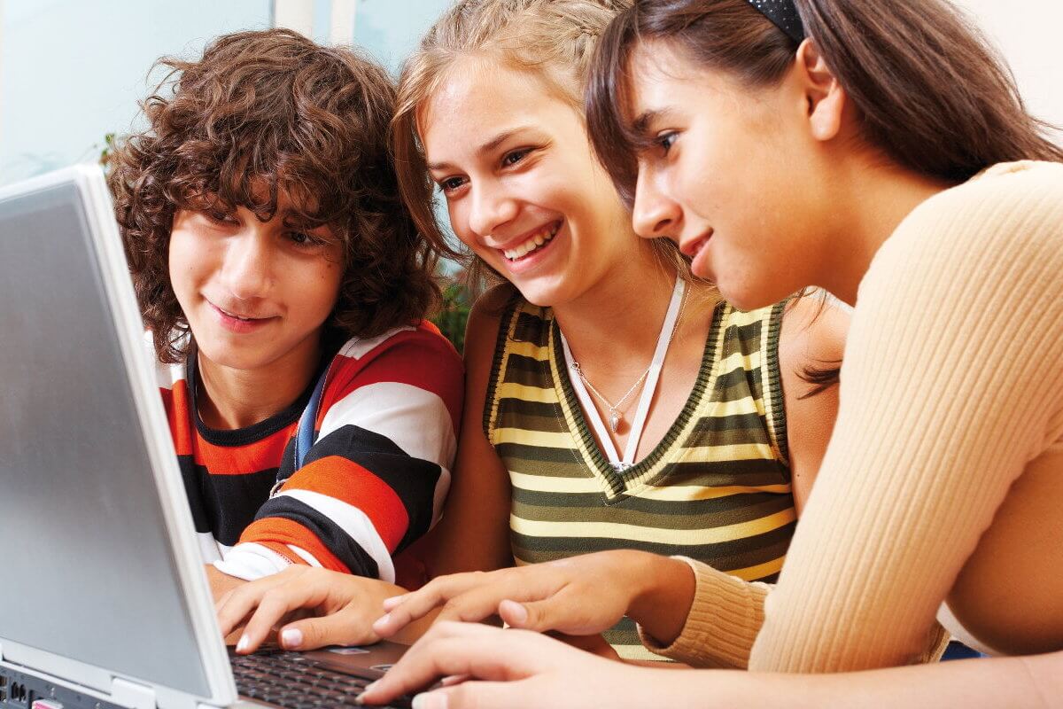 drei Auszubildende arbeiten am Laptop